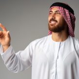 young-arab-man-pointing-hand-copy-space-gray-background_93675-144863